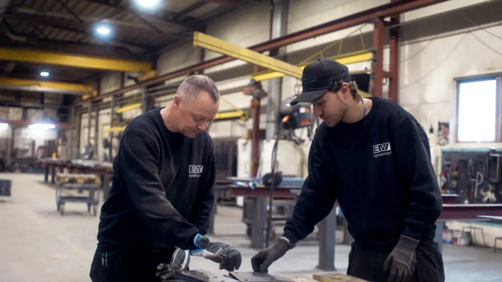 To ansatte hos EMV Construction samarbeider om bearbeiding av metallplater i verkstedet på Magnor.
